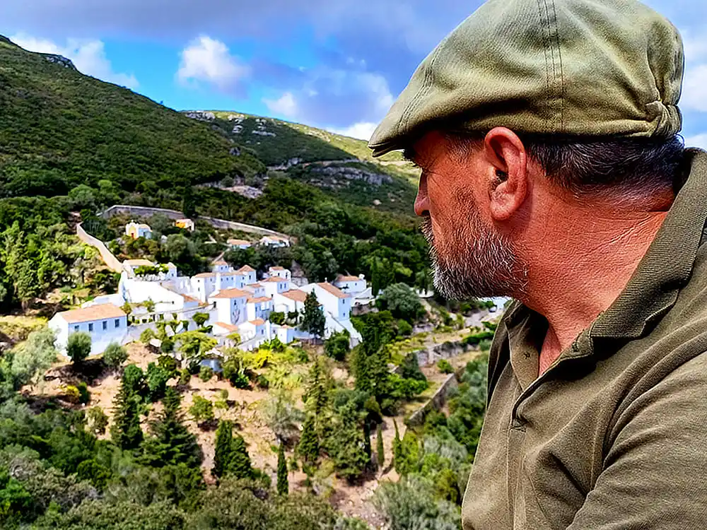 Perfil de guia de caminhadas com vista sobre o Convento da Arrábida ao fundo.