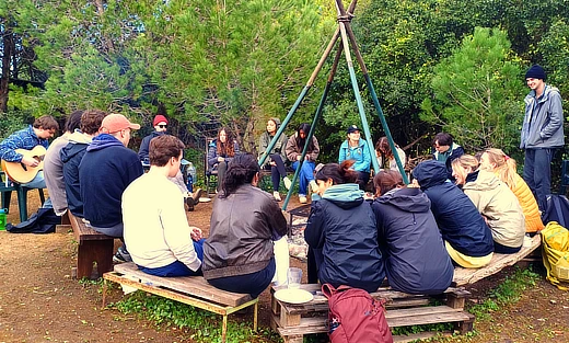 Grupo de jovens à volta da fogueira, atividade de turismo de natureza organizada por Arrábida Walks & Crafts